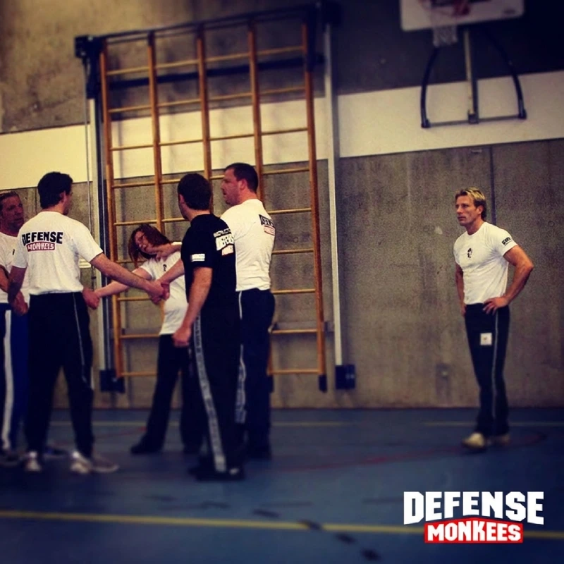 Krav Maga groepsles bij DefenseMonkees waarbij cursisten onder begeleiding van een instructeur zelfverdedigingstechnieken oefenen in de sportschool.